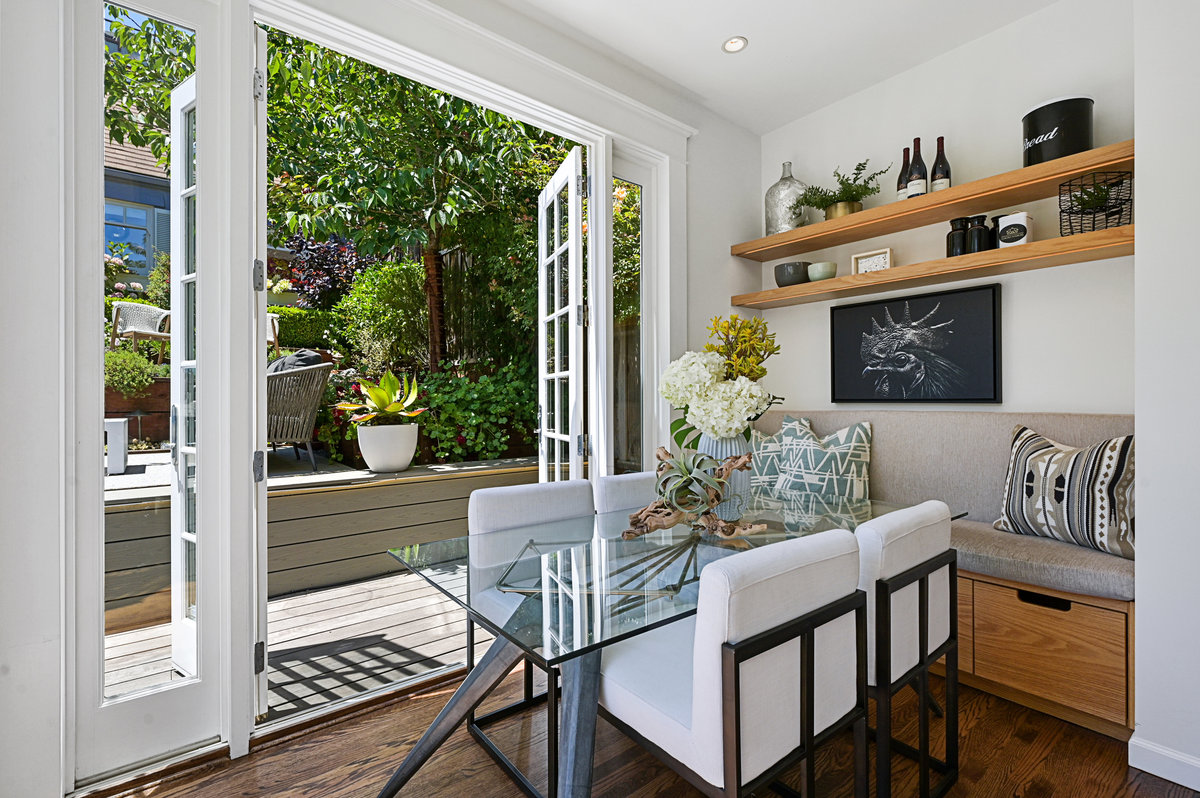 Dining area opens to garden + deck via two walls of French doors